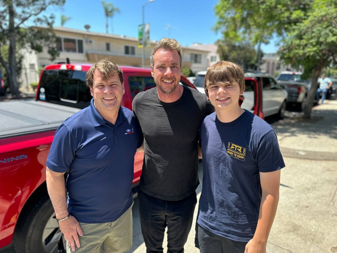 Jim Farley and his son Jameson Farley pose for a photo with Dax Shepard.